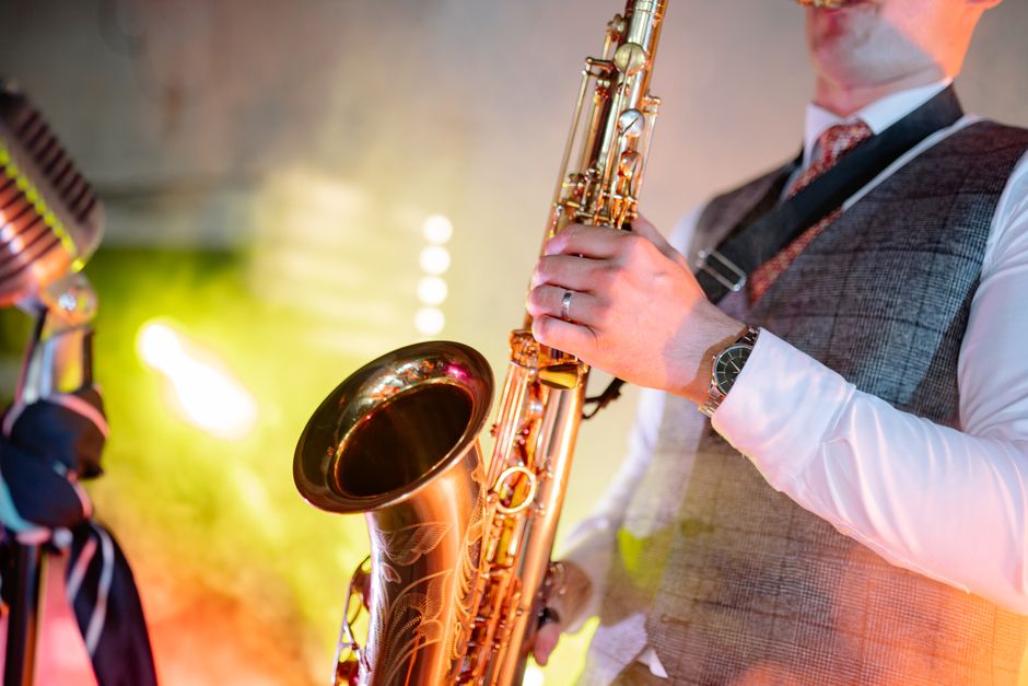 A musician passionately playing the saxophone, showcasing talent under colorful stage lights.